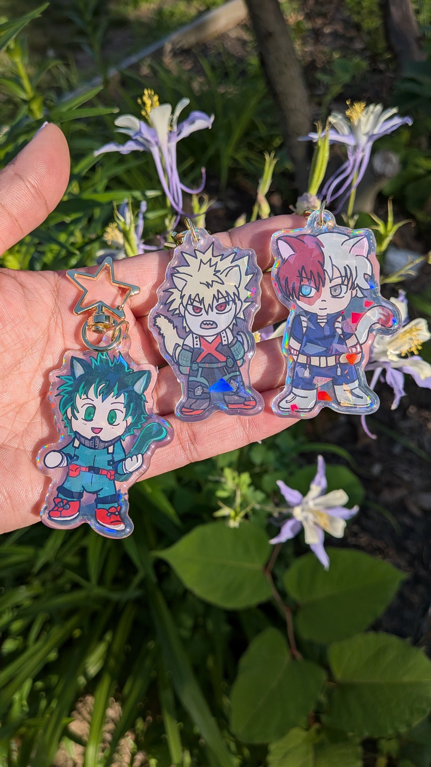 Holographic acrylic keychains of The Origin Trio from My Hero Academia held in a hand