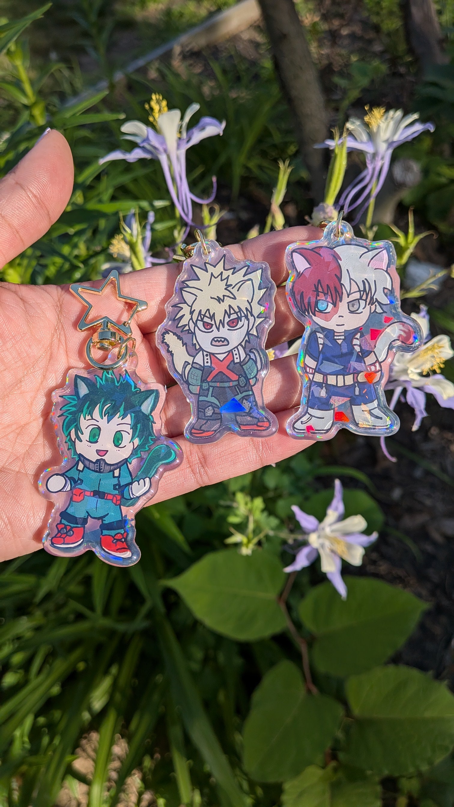 Holographic acrylic keychains of The Origin Trio from My Hero Academia held in a hand