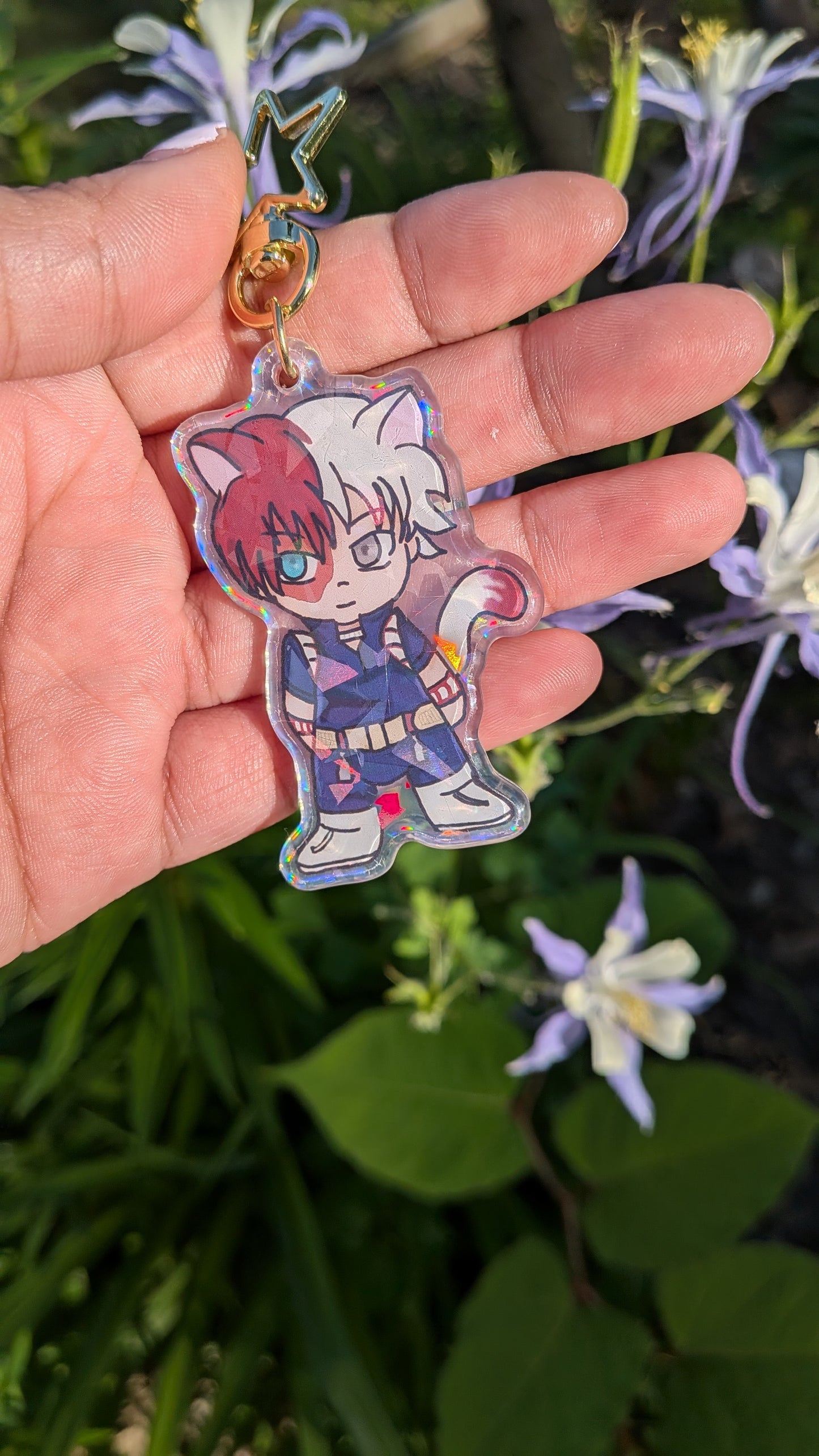Hand holding a transparent keychain of Shoto Todoroki drawn in a chibi form with cat ears 