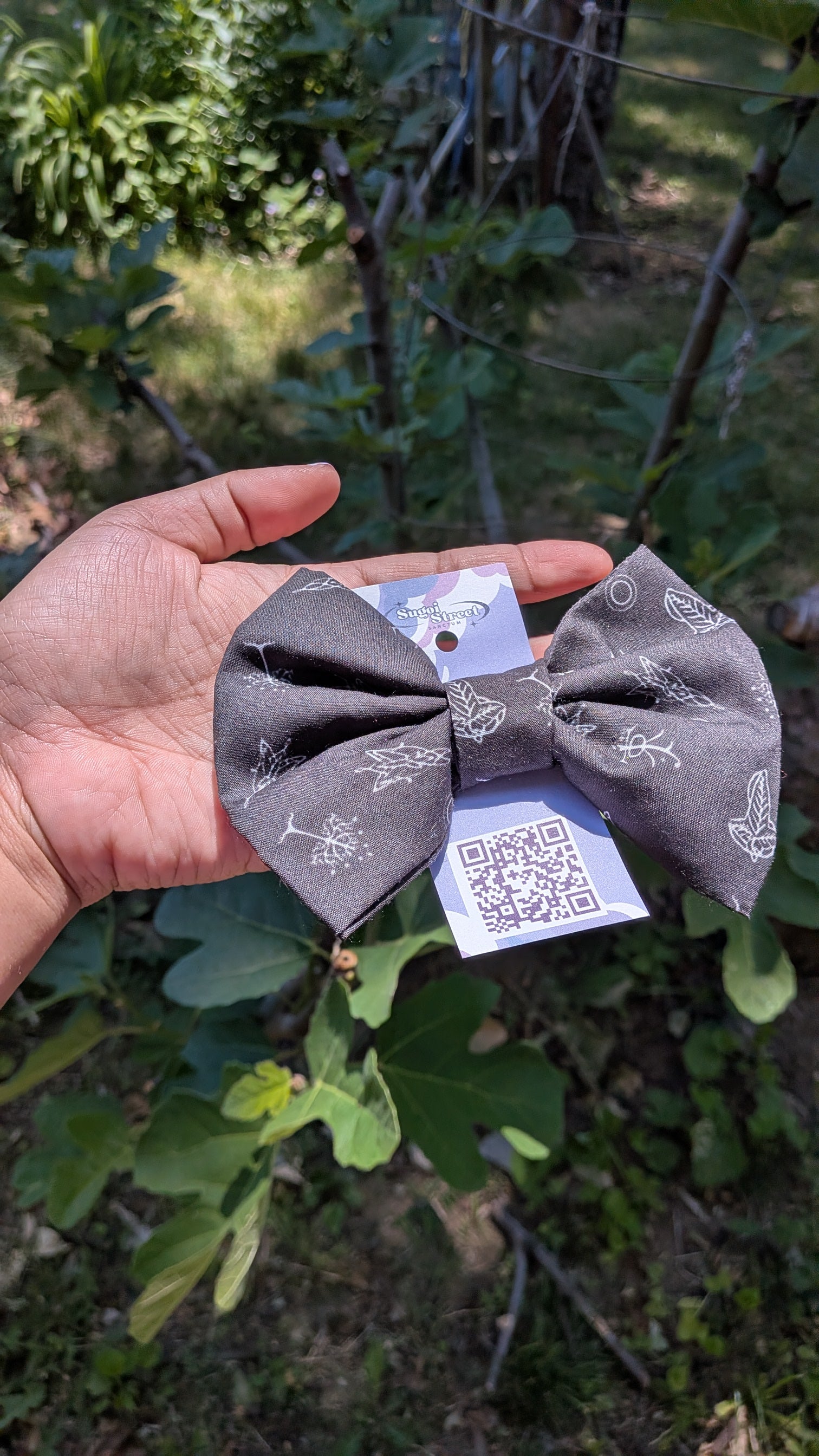 Black hair bows with white patterns held in a hand