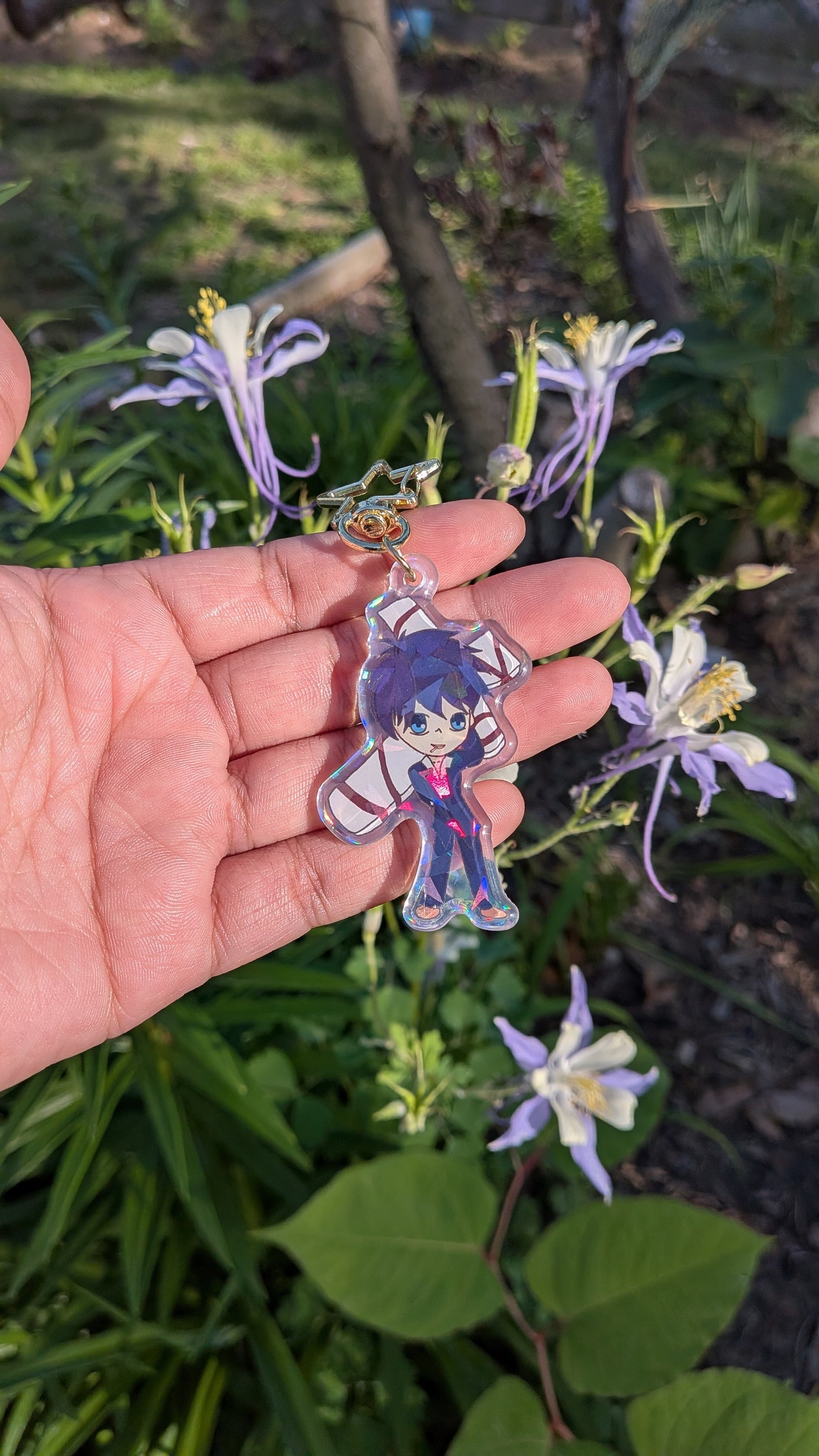 Hand holding a colorful keychain of Wolfwood
